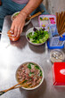 © Studio KME/Stocksy - Hand Picking Up Chili Sauce at a Vietnamese Eatery