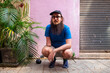 © Studio KME/Stocksy - Bearded Man Squatting by a Pink Wall