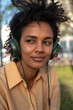 © tessy morelli/Stocksy - Close portrait of woman listening music in the park