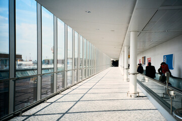 Long corridor in an airport with travelers heading to gates