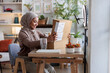 © Jovo Jovanovic/Stocksy - Excited woman opening package on table at home