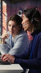 Poster - Vertical video Call center team leader supervising agent helping customers regain access to accounts and devices. Customer center manager overseeing intern assisting clients needing help resetting