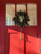 © Simone Anne/Stocksy - Christmas wreath on a red front door