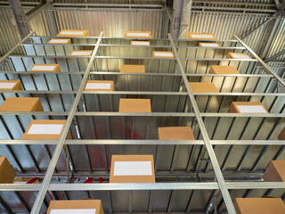 Poster - Industrial rack for storing products. Cardboard boxes in warehouse. Furniture for factory storage area. Industrial shelving inside hangar. Warehouse furniture for long-term storage.
