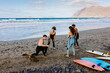 © Adrian Rodd/Stocksy - Surfing enthusiastic friends take a lesson with a professional surfer