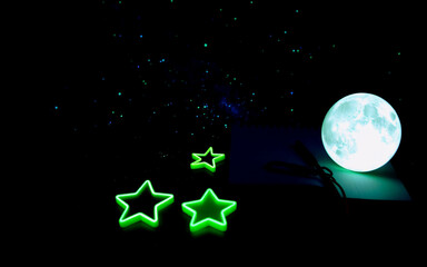 Wall Mural - glowing cyan moon and stars brightly illuminate the deep dark night sky in a celestial and dreamy sc