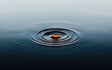 Poster - Abstract image of a small orange sphere resting on dark blue water, creating concentric ripples. The background is a gradient of light blue and gray.  The overall mood is serene and tranquil