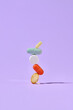 © Marc Tran/Stocksy - Colorful Pills Balancing on Purple Background in Abstract Concept