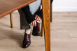 © Viktor Solomin/Stocksy - Person tying shoelaces while sitting at a wooden table