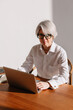 © Viktor Solomin/Stocksy - Professional woman working on laptop in modern office