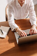 © Viktor Solomin/Stocksy - Professional woman typing on laptop at wooden desk with notepad
