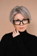 © Viktor Solomin/Stocksy - Stylish older woman with gray hair and glasses in a black turtleneck