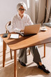 © Viktor Solomin/Stocksy - Professional woman working on laptop in a bright and modern office