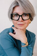 © Viktor Solomin/Stocksy - Mature woman in stylish outfit poses thoughtfully