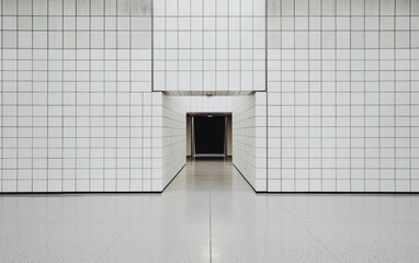 Poster - Abstract hallway with white walls and floor, geometric lines, and a dark doorway at the end.  Clean, minimalist design. Symmetrical composition