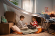 © Danil Nevsky/Stocksy - Brother and sister playing cards in a blanket fort in their bedroom