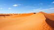 © akhmad - Vast orange sand dunes under a clear blue sky