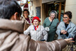 © Alvaro Lavin/Stocksy - Family welcoming elderly woman with open arms in front of restaurant