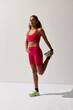 © Javier Díez/Stocksy - Fitness enthusiast stretching her leg in vibrant athletic wear