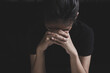 © Tinnakorn - A depressed young woman sits sadly on a sofa, covering her face with her hands. Depressing atmosphere. Relationship problems. Violence against women.