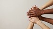 © Vyatcheslav - Diverse hands stacked together in unity against a neutral background