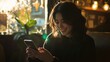 © Arianne - Smiling woman using smartphone in cafe with backlight