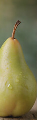 Poster - A ripe green pear with a brown stem is showcased in a close-up shot, displaying water droplets on its smooth skin.