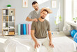 © Studio Romantic - Professional chiropractor, osteopath or physiotherapist helping get rid of neck pain to young man patient who is sitting on medical massage bed at clinic