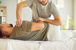 © Studio Romantic - Professional male chiropractor or osteopath specialist works with adult man in manual therapy office. Osteopathic physician help patient with pain relief in upper body using controlled movements.