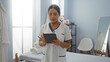 © Krakenimages.com - Woman wearing spa uniform uses tablet in serene wellness room, surrounded by towels and furniture, suggesting focus on relaxation and beauty services.