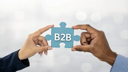 Poster - Hands holding a blue b to b puzzle piece against a blurred white background in a studio shot