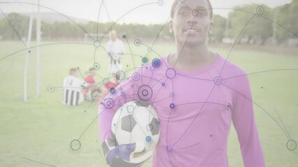 Poster - Soccer player holding ball with network connections animation over field scene