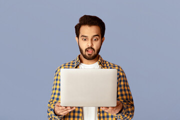 Poster - Shocked Indian guy staring at laptop screen with open mouth on lilac background