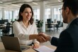 © Vishwesh - Smiling Businesswoman in White Shirt Shaking Hands with Colleague During Job Interview or Business Agreement in Modern Office