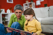 © Miljan Živković - grandmother and grandchild spend time together and read a book at home