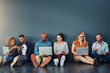 © Tamani Chithambo/peopleimages.com - Studio, floor and group of business people at with laptop, smile and online connectivity with mockup space. Tech agency, team and creative friends relax with digital networking on grey background