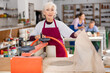 © JackF - lady with gray hair makes crafts out of clay by machine clay press Roller