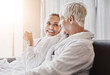 © Camerene P/peopleimages.com - Mature couple, sofa and relax with coffee in gown or robe for luxury spa day together at resort. Senior man or woman with smile for morning, beauty or relaxation treatment on holiday getaway in suite