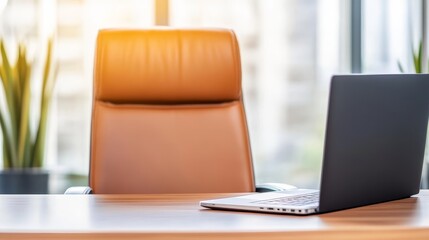 Poster - Modern office workspace with a sleek laptop on a wooden desk and an empty leather chair