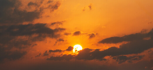 Wall Mural - sun sets behind the clouds, beautiful bright sunset sky with dramatic clouds. sunset sky background.