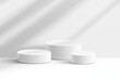 © EnelEva - Minimalist white cylindrical podiums create serene display in bright space