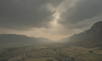 Poster - A dramatic landscape unfolds with sun rays piercing through dark, heavy clouds casting shadows across a valley surrounded by majestic mountains. The scene evokes a sense of awe and atmospheric depth.