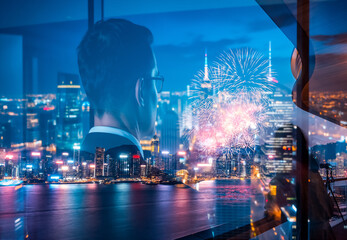 Aufkleber - A double exposure image featuring a man looking out at the Hong Kong skyline illuminated with fireworks at night, seen through a window with city reflections.