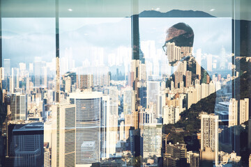 Aufkleber - A double exposure blends a man gazing out a window with Hong Kong's cityscape. Buildings overlay, creating a layered urban scene.