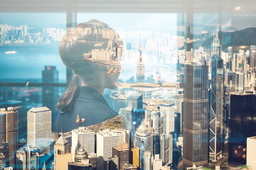 Fototapete - A double exposure image of a woman looking over the cityscape of Hong Kong. The city skyline is visible through the silhouette of a person.