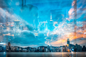Fototapete - Hong Kong skyline at dusk with a double exposure effect, blending city lights and evening sky over the harbor. Urban reflections create a layered, artistic view.