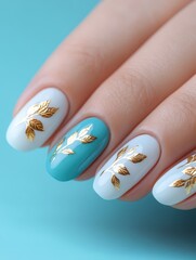 Poster - Decorative nail art features a mix of light blue and white polish adorned with delicate gold leaf patterns. The nails are neatly manicured and showcased against a vibrant backdrop