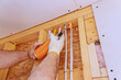 © ungvar - Worker uses spray foam adhesive insulation to secure electrical components in home renovation,