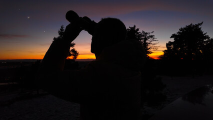 Wall Mural - amateur astronomer looking at the evening skies, observing planets, stars, moon and other celestial 
