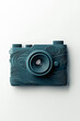 © Alexandre Patchine - Teal camera with wavy design on white background, representing minimalist style and modern technology, perfect for photography and design concepts